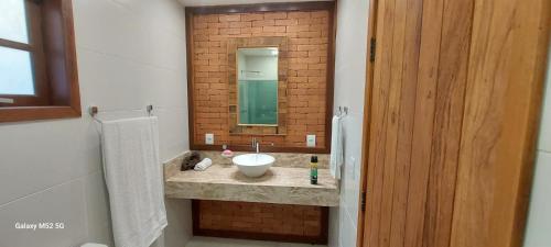 La salle de bains est pourvue d'un lavabo et d'un miroir. dans l'établissement Chalés dos amores, à Visconde de Mauá