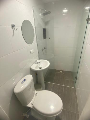 a white bathroom with a toilet and a sink at 22 APARTAMENTO 3 habitaciones CON BALCON EN LAURELES ESTADIO in Medellín