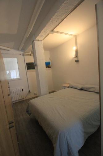 1 dormitorio con cama blanca y ventana en La Casita de Vicálvaro, en Madrid