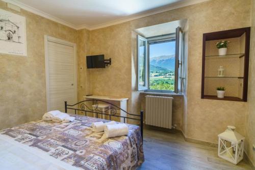 a bedroom with a bed and a large window at B&B La Locanda del Serafino in Sarnano