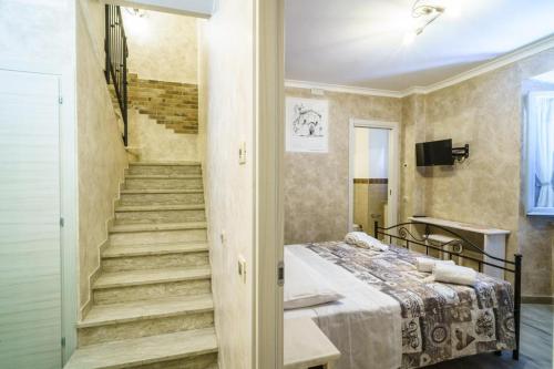 a room with a bed and a staircase in it at B&B La Locanda del Serafino in Sarnano