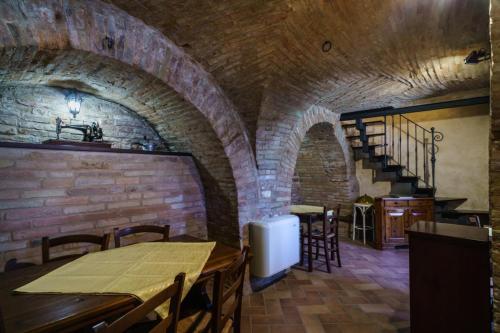 a restaurant with tables and chairs and a brick wall at B&B La Locanda del Serafino in Sarnano