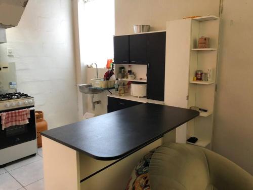 uma cozinha com um balcão preto num quarto em Acogedora Casa en Trujillo Moche em Trujillo