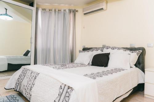 a bedroom with a bed with white sheets and a window at Luxury 2 Bedroom with Pool & Hot-tub in Santo Domingo