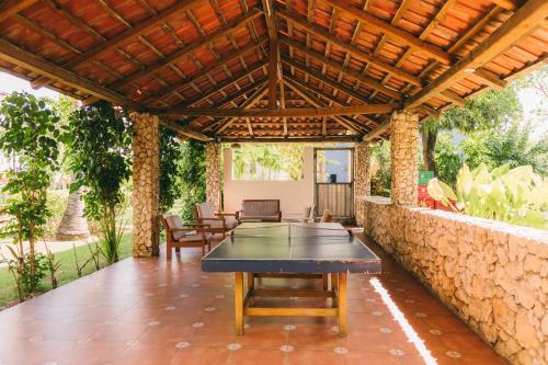 a ping pong table on a patio with a stone wall at Luxury 2 Bedroom with Pool & Hot-tub in Santo Domingo