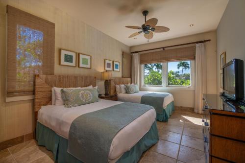 a hotel room with two beds and a flat screen tv at Mauna Lani Luxury Vacation Villas - CoralTree Residence Collection in Waikoloa