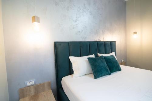 a bed with a green headboard in a room at Melnaz Apartament 2 in Korçë