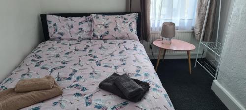 a bedroom with a bed with a pillow and a table at 2 Bed Flat North London in Edmonton