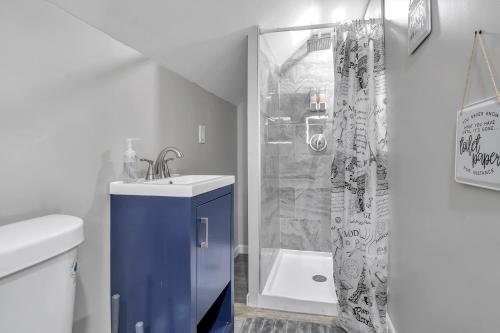 a white bathroom with a sink and a shower at The Mapleridge Retreat in Buffalo