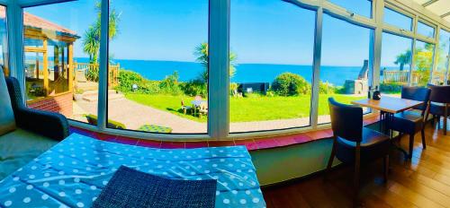 a room with a large window with a view of the ocean at Villa Mentone Hotel in Shanklin