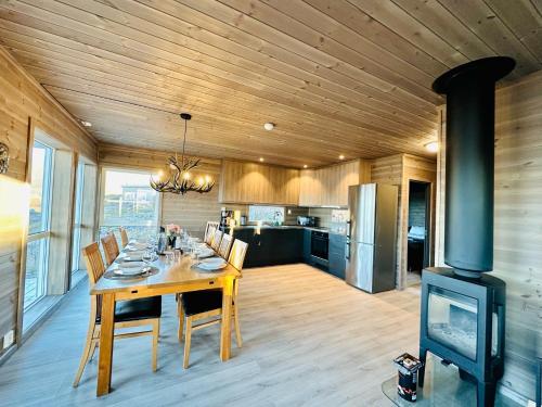 een eetkamer met een tafel en een fornuis bij Lofotenholidays, Luxury cabin with panoramic view in Leknes