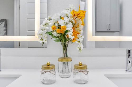 eine Vase mit Blumen, die auf einer Badezimmertheke liegt in der Unterkunft Midtown Houston Luxury Suite at River Oaks in Houston