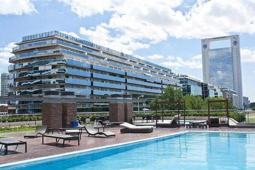 un gran edificio con piscina frente a un edificio en Puerto Madero Piso 20 Vista al Rio frente a Hilton en Buenos Aires