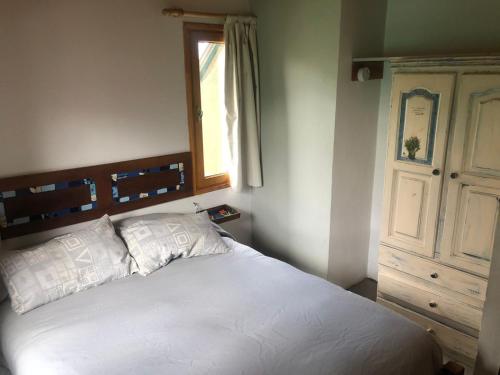 ein Schlafzimmer mit einem weißen Bett und einem Fenster in der Unterkunft El Tranco - Casa "Bajada Poujardieu" in Junín de los Andes