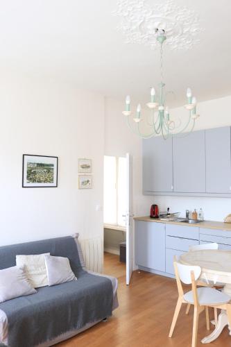 un salon avec un canapé et une table dans l'établissement Le Petit Mansart, à Versailles