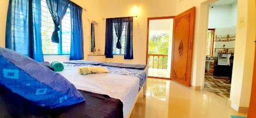 a bedroom with two beds with blue curtains at BLUE SOPHY Residency in Varkala