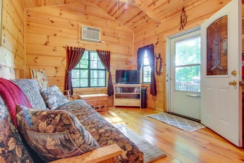 a living room with a couch and a tv at Hendersonville Creekside Cabin Near DuPont Forest in Hendersonville