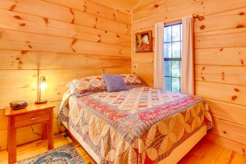 a bedroom with a bed in a log cabin at Hendersonville Creekside Cabin Near DuPont Forest in Hendersonville