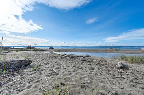 a sandy beach with the ocean in the background at Coastal PNW Home on Swimmable Beach with Hot Tub! in Stanwood