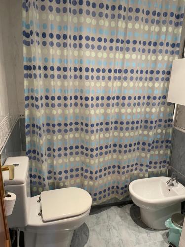 a bathroom with a toilet and a shower curtain at Nou Mestalla in Valencia
