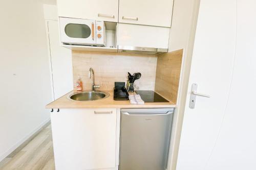 une petite cuisine avec un évier et un micro-ondes dans l'établissement #GB Au Coeur de l'Essentiel 2, à Saint-Martin-le-Vinoux