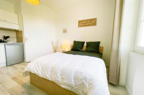 um quarto com uma grande cama branca e uma cozinha em At the heart of the essential 2 - New studio #GB em Saint-Martin-le-Vinoux