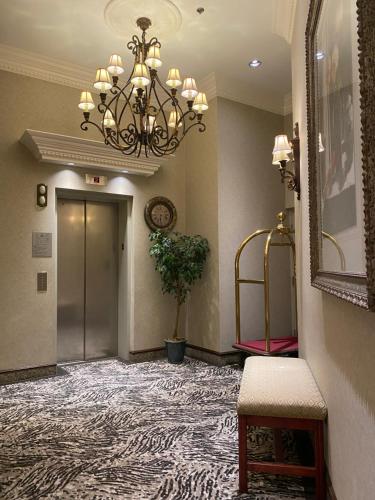 a hallway with a chandelier and a door with a carpet at Kingston Hotel in Vancouver