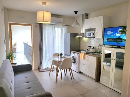 a kitchen and living room with a table and a tv at Beach Apartments Old Town in Estepona