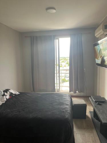 1 dormitorio con cama y ventana grande en Dpto zona céntrica con yacuzzi en San Lorenzo
