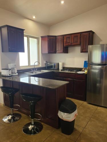 a kitchen with wooden cabinets and a stainless steel refrigerator at Guest House with Shared Pool Access in David