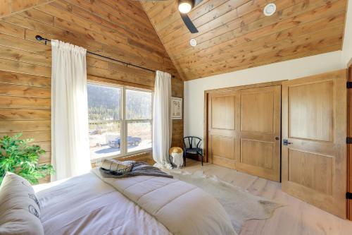 Brand New Idaho Springs Cabin with Patio and Fire Pit! في أيداهو سبرينغز: غرفة نوم بسرير كبير وسقف خشبي
