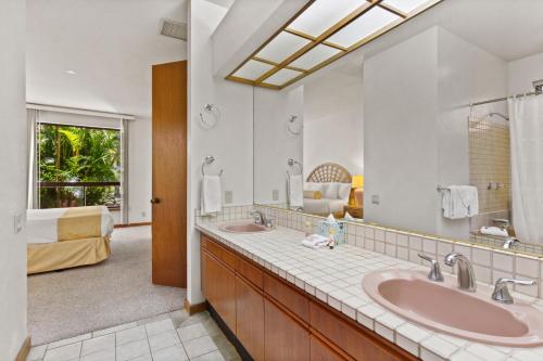 a bathroom with two sinks and a large mirror at Shores at Waikoloa 112 - MCH in Waikoloa