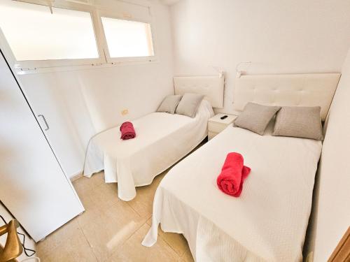 2 Betten in einem Zimmer mit roten Hausschuhen darauf in der Unterkunft Sunset 408 heated pool with views in Adeje