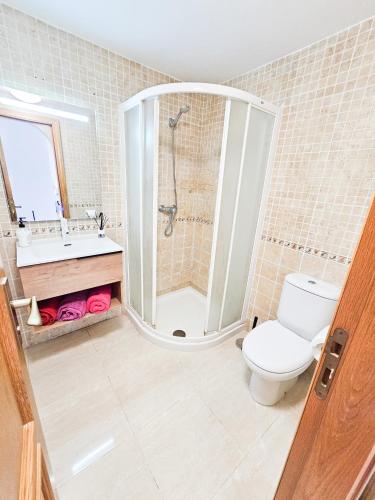 a bathroom with a shower and a toilet and a sink at Luxury Sunset 408 heated pool with air condition and sea views in Adeje