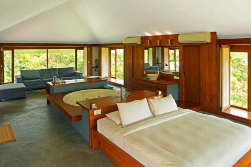 a bedroom with a bed and a living room at The Dune Eco Village and Spa - Pondicherry in Pondicherry