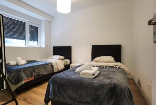 1 dormitorio con 2 camas y toallas. en Maison Disney, Paris, Val d'Europe, en Quincy-Voisins