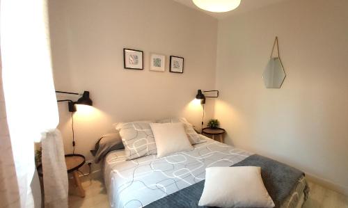 um quarto com uma cama branca e 2 candeeiros em Les Capitouls - avec entrée autonome, jardin & parking privé ! - em Toulouse