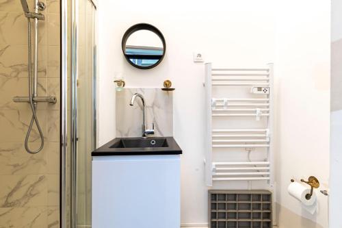 une salle de bain avec un lavabo et une douche dans l'établissement Comme à la Maison, à Paris