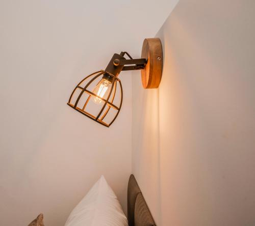 a light fixture on a wall next to a bed at B49 - City & Messe Apartment in Cologne