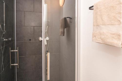a bathroom with a shower with a glass door at B49 - City & Messe Apartment in Cologne