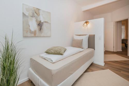 a bed in a room with a picture on the wall at B49 - City & Messe Apartment in Cologne