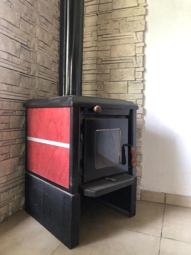 a wood stove in a room with a brick wall at El Tranco - Casa "Tu Lugar" in Junín de los Andes