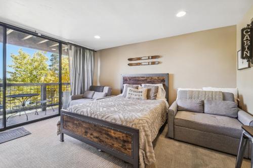 a bedroom with a bed and a couch and a balcony at Truckee Studio with Balcony and On-Site Skiing! in Truckee