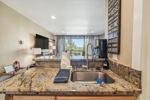 a kitchen with a sink and a living room at Truckee Studio with Balcony and On-Site Skiing! in Truckee