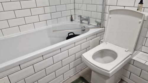 a white bathroom with a toilet and a sink at House in London