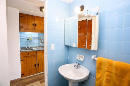 a blue bathroom with a sink and a mirror at Center Bariloche in San Carlos de Bariloche