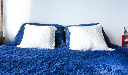 manta azul con 2 almohadas en una cama en Center Bariloche en San Carlos de Bariloche