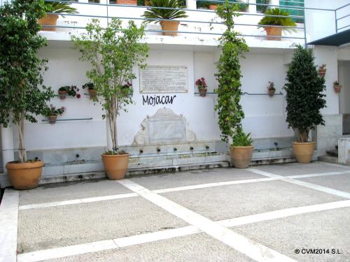 a building with potted plants on the side of it at Centro Vacacional Macenas in Mojácar