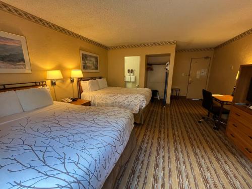 a hotel room with two beds and a desk at Travelodge by Wyndham Seattle By The Space Needle in Seattle