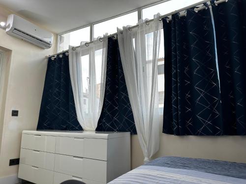 um quarto com cortinas pretas e brancas e uma cama em Benalmádena em Benalmádena